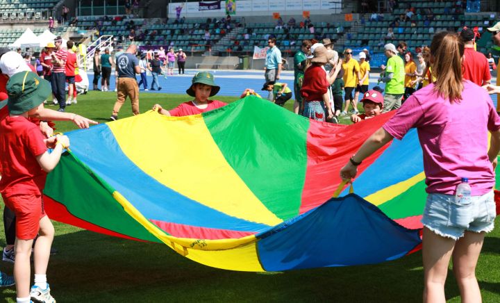 Students and adult play the parachute game in the stadium at Sports Carnival 2018